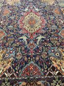 A fringed Persian carpet on blue ground