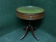 A circular yew wood drum table inset with green leather panel on four way support
