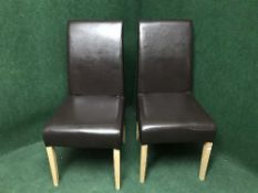 A pair of high backed brown leather dining chairs