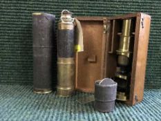 A brass pocket telescope in sleeve together with a miniature brass microscope in fitted mahogany
