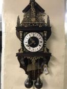 A Continental mahogany and brass wall clock with pendulum and weights