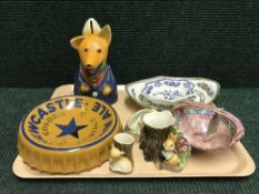 A tray of pottery Bazil Brush money box, Newcastle Brown ale bottle topped ashstray,