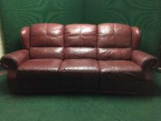 A burgandy leather three seater reclining settee