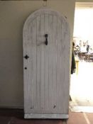 A pine arched door with metal fittings and door knocker with key