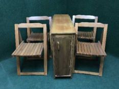 A contemporary drop leaf kitchen table containing four folding chairs