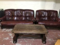 A wood framed burgandy leather three seater settee,