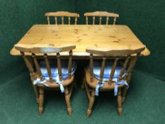 A pine kitchen table and four spindle back chairs
