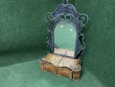 A metal and wicker mirror fitted with a drawer