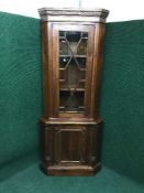 A reproduction mahogany corner cabinet