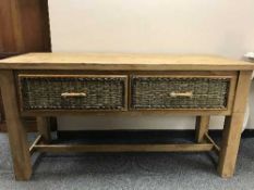 A reclaimed pine two drawer side table with wicker drawers
