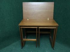 A mid twentieth century teak turn over topped trolley fitted with two tables underneath
