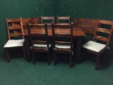 A contemporary hardwood dining table with extension leaves together with a set of six ladder backed