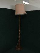 A heavily carved mahogany standard lamp and shade