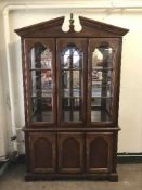 A stained beech triple door display cabinet