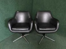 A pair of black vinyl swivel chairs on chrome bases