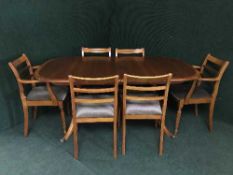 An inlaid mahogany extending dining table fitted a leaf and six dining chairs