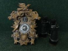 A pair of early 20th century field glasses and a Kaiser cuckoo clock with pendulum and weights