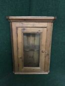 A pine glazed door hanging corner cabinet