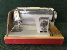 A cased Jones electric sewing machine and sewing accessories