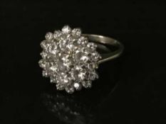 An impressive 18ct white gold diamond cluster ring, the seven larger stones weighing an estimated 2.