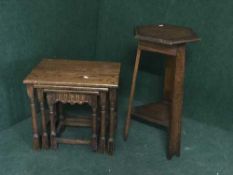 A nest of three oak tables together with a hexagonal oak two tier plant stand