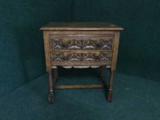 A heavily carved oak side cabinet fitted with two drawers