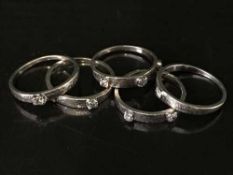 High carat white gold, tests 18, five-piece diamond ring with 9 stones approximately .6 carat, 8.