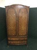 A walnut Queen Ann style double wardrobe fitted with drawers