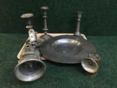 A tray of antique pewter charger, pewter candlesticks,