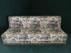 An early twentieth century day-bed upholstered in floral fabric