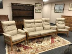 An Ercol elm three piece lounge suite comprising of three seater settee and pair of matching chairs