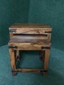 A nest of two stained pine tables with metal mounts