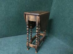 A miniature oak gate leg table on turned leg