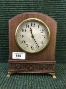 A mahogany mantel clock on brass bracket feet