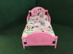 A child's Minnie Mouse bed with bedding
