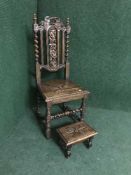 A heavily carved oak dining chair and a carved oak footstool