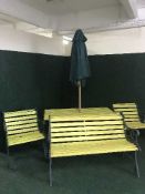 A four piece wrought iron and wood patio set comprising of table,