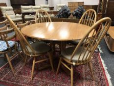 An Ercol light elm circular pedestal dining table and four Quaker Windsor chairs