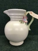 A Clarice Cliff beige pottery jug with floral handle