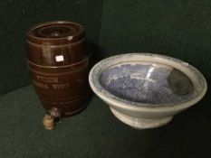 A pottery Etherium drinking water barrel with tap and an antique blue and white toilet bowl