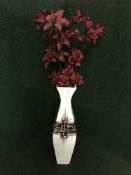 A large contemporary pottery vase containing artificial flowers