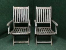 A pair of teak garden chairs