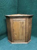 An oak hanging corner cupboard
