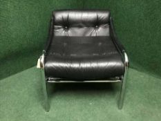 A mid 20th century and black button leather armchair