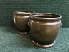 A pair of Japanese style bronze planters depicting mythical beasts