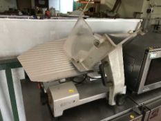 A commercial stainless steel meat slicer