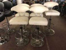 A set of five cream leather swivel bar chairs on chrome bases