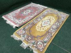 A pink fringed embossed Chinese rug and one other