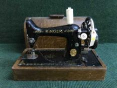 An oak cased Singer hand sewing machine