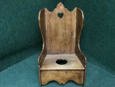 An antique pine child's rocking commode chair